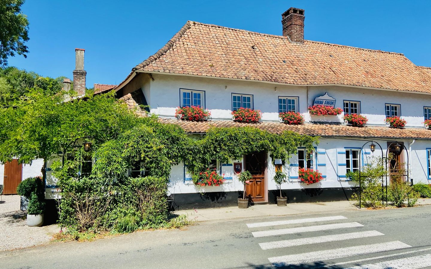 Façade blanche fleurie de l'auberge d'Inxent, vallée de la Course